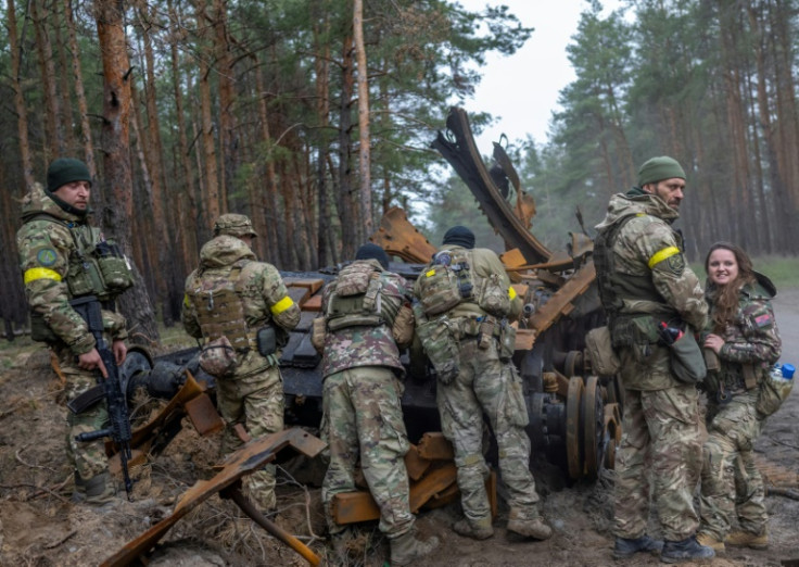 Tentara Ukraina dan pejuang sukarela memeriksa tank Rusia yang hancur di Ukraina timur