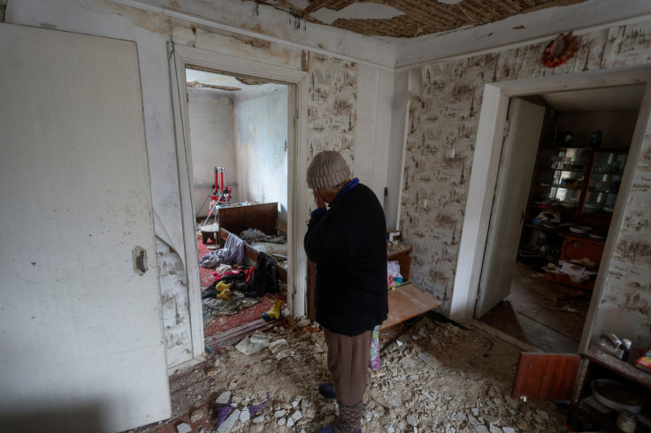 Nina Stovba reacts as she stands inside a house of her neighbour rubbered by Russian soldiers and damaged by a military strike in the village of Blahodatne in Kherson region