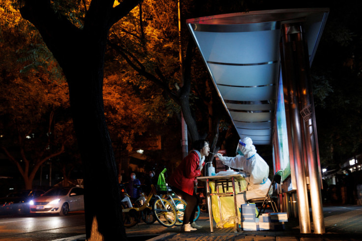 A woman gets a swab tests at a temporary testing station as outbreaks of COVID-19 continue in Beijing