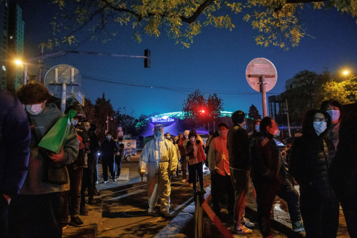 People line up to get swab tests at a testing booth as outbreaks of COVID-19 continue in Beijing