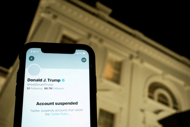 : A photo illustration shows the suspended Twitter account of U.S. President Donald Trump on a smartphone and a lit window in the White House residence in Washington