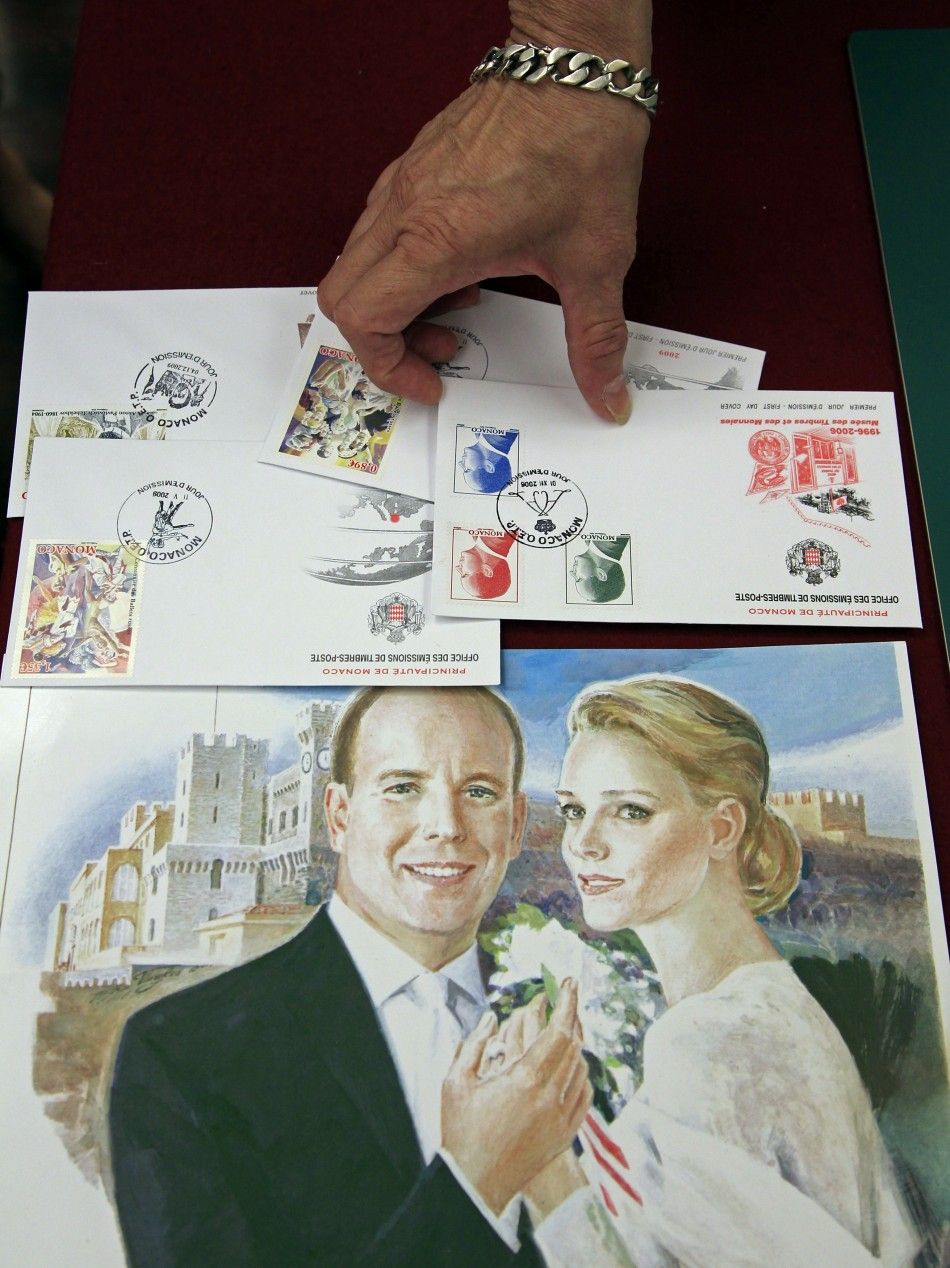  An official displays commemorative stamps to mark the wedding of Prince Albert II of Monaco and his fiancee Charlene Wittstock in Monaco