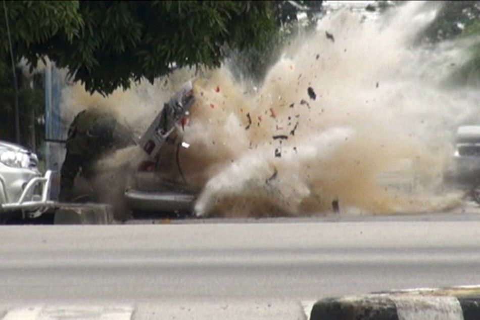 A car bomb explodes as a member of a Thai bomb squad checks it in Narathiwat province