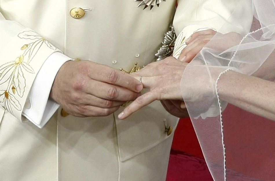 Prince Albert II of Monaco puts the wedding ring on the finger of his bride Princess Charlene during their religious wedding ceremony