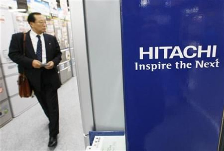 A man walks past Hitachi&#039;s logo at an electronic shop in Tokyo