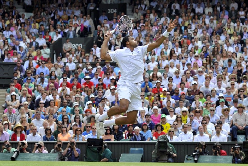 Jo-Wilfried Tsonga of France hits a return to Roger Federer of Switzerland during their quarter-final match at the Wimbledon tennis championships in London June 29, 2011.