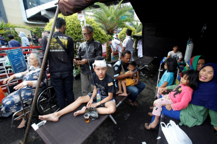 Wounded people rest under a tent displayed outside a hospital following an earthquake in Cianjur