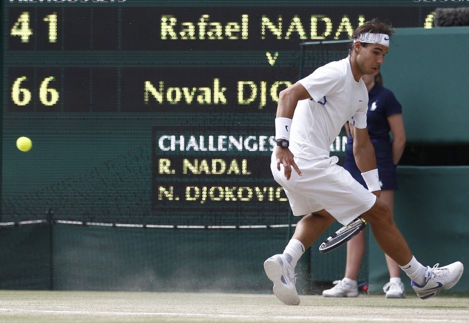 Rafael Nadal of Spain attempts to hit a return through his legs during his men039s singles final match against Novak Djokovic of Serbia at the Wimbledon tennis championships in London.