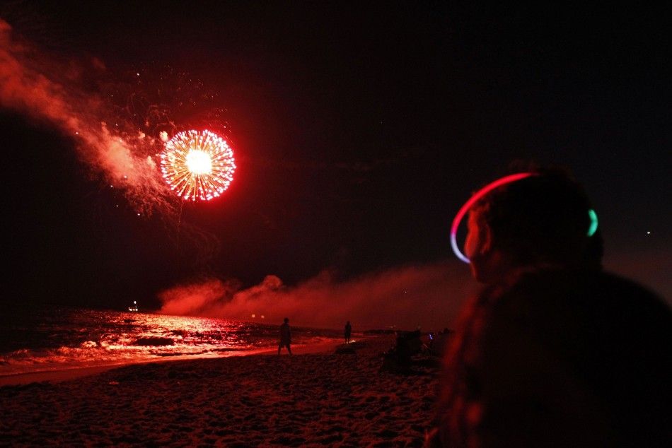 A boy watches fireworks during holiday celebrations held on the eve of Fourth of July at Atlantic Beach