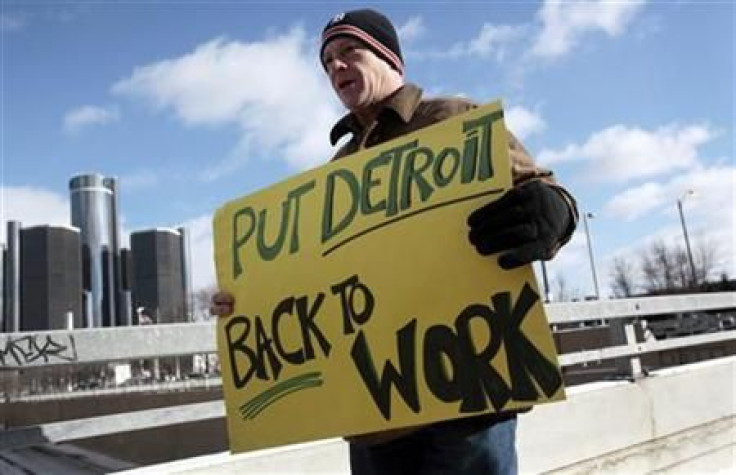 Unemployed worker Pollock carries a sign outside Cobo Center to demonstrate for jobs and good wages before start of press days at North American International Auto show in Detroit, Michigan