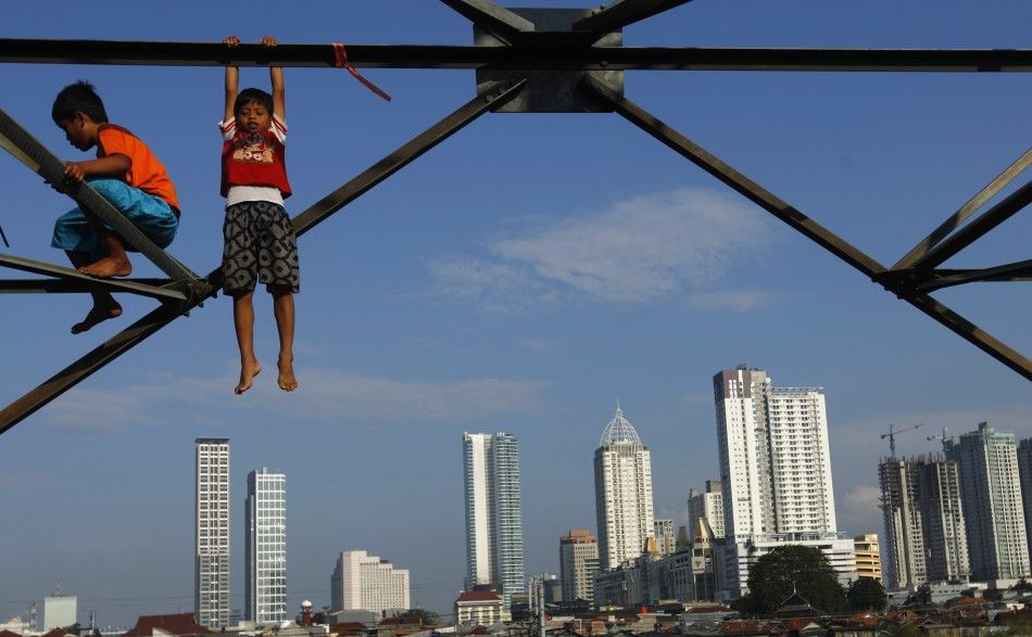 Children play at an electricity pylon in Jakarta, February 11, 2011.
