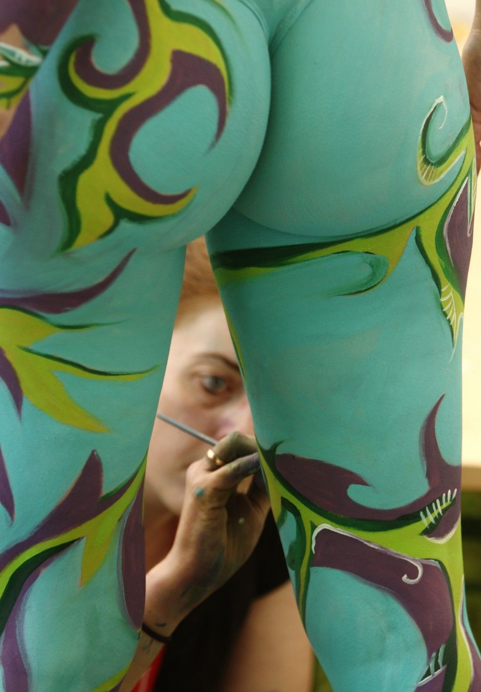An artist paints a model during the annual World Bodypainting Festival in Poertschach