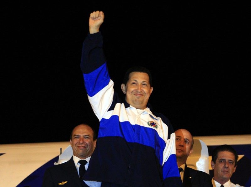 Venezuelas President Hugo Chavez gestures from the doorway of a plane upon arrival from Cuba