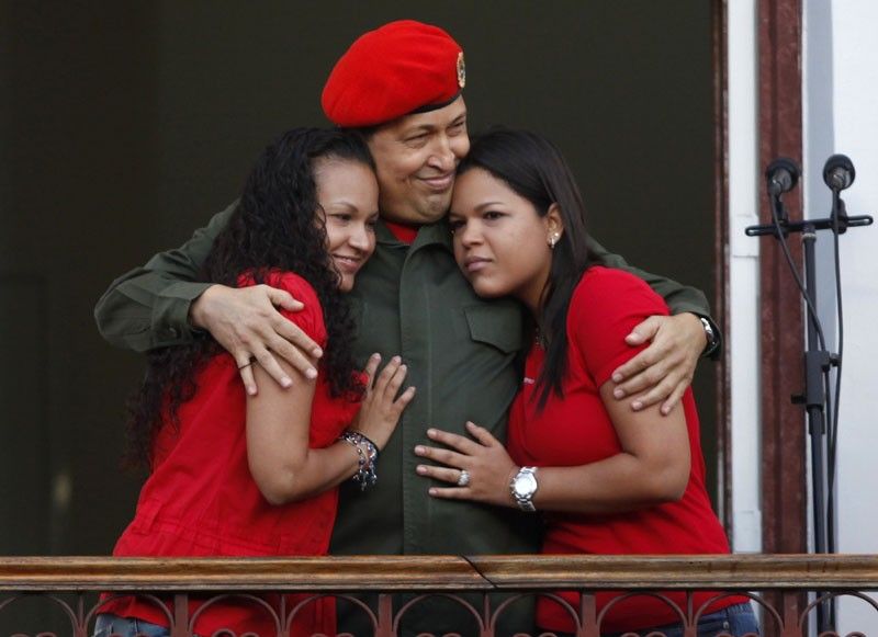 Venezuelas President Hugo Chavez hugs his daughters in Caracas