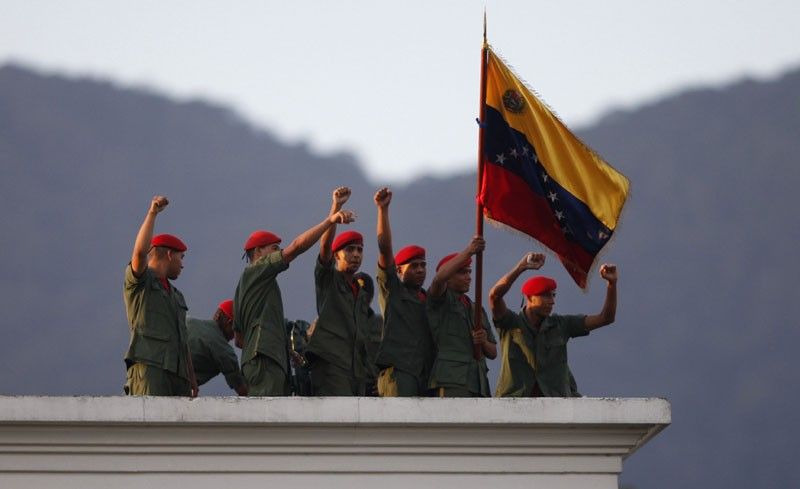 Venezuelan soldiers greet President Hugo Chavez from a rooftop