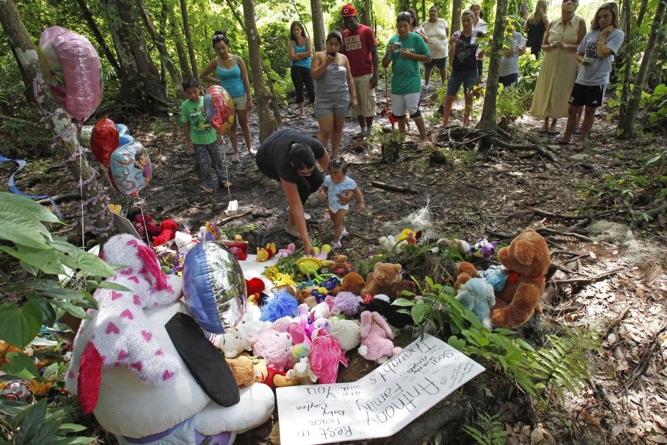 Neighbors gather at the wooded location of where the body of Caylee Anthony was found
