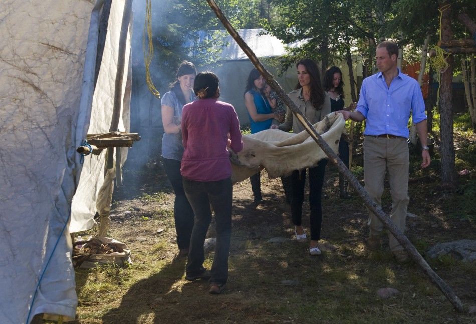 Britain039s Prince William and his wife Catherine help carry a caribou skin to a tent while visiting Blatchford Lake