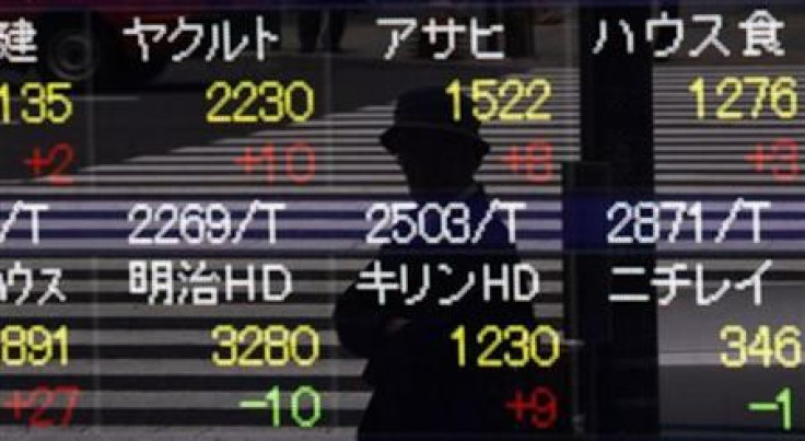 A pedestrian is reflected in a stock index board outside a brokerage house in Tokyo