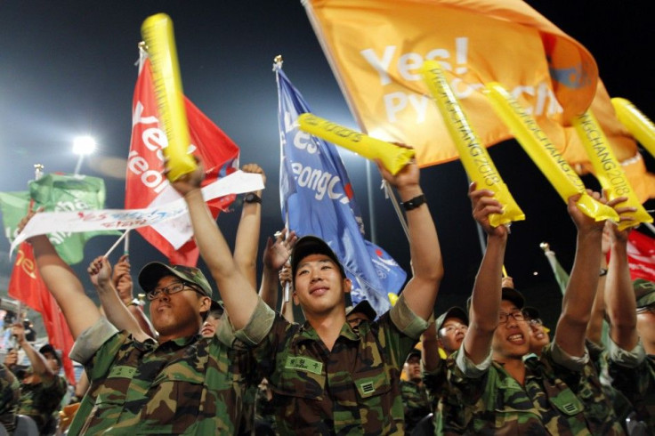 South Korean Army soldiers cheer as they hear that Pyeongchang would win in a first round of voting for the 2018 Winter