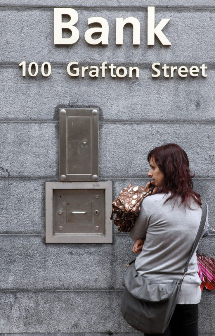 A woman stands outside a bank on Grafton Street in Dublin
