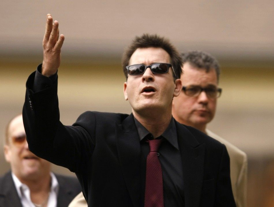 Actor Charlie Sheen gestures towards fans as he arrives for a sentencing hearing at the Pitkin County Courthouse in Aspen