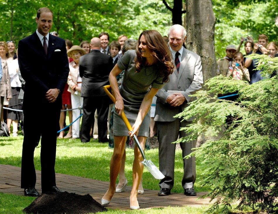 Britain039s Prince William L watches as his wife Catherine, Duchess of Cambridge wields a shovel