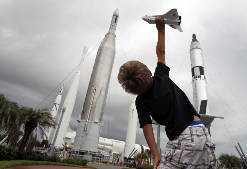 Freddy Porter of Raleigh N.C. plays with a toy space shuttle in the Rocket Garden of the Kennedy Space Center Visitor Complex