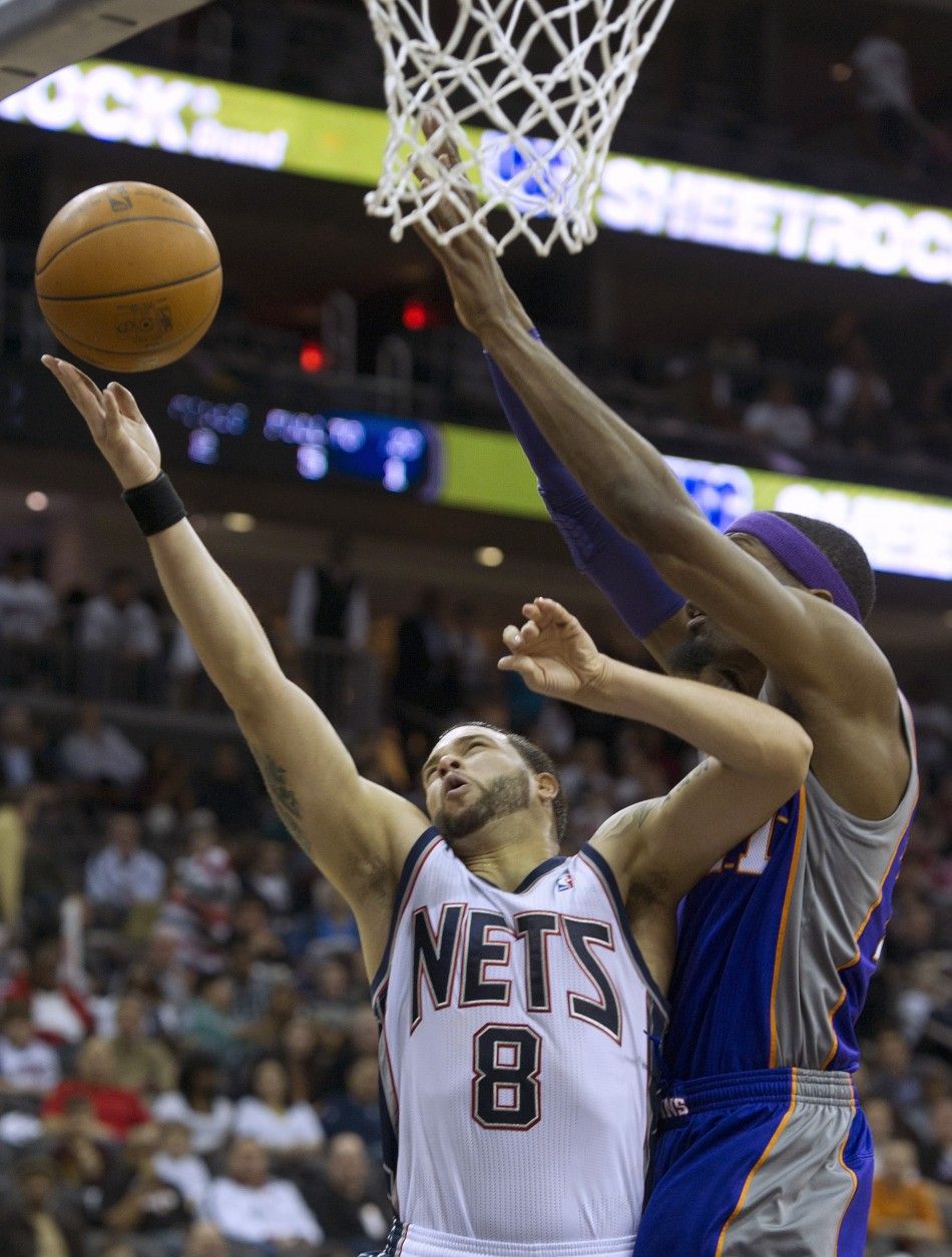New Jersey Nets Williams tries layup past Phoenix Suns Warrick in their NBA basketball game in Newark