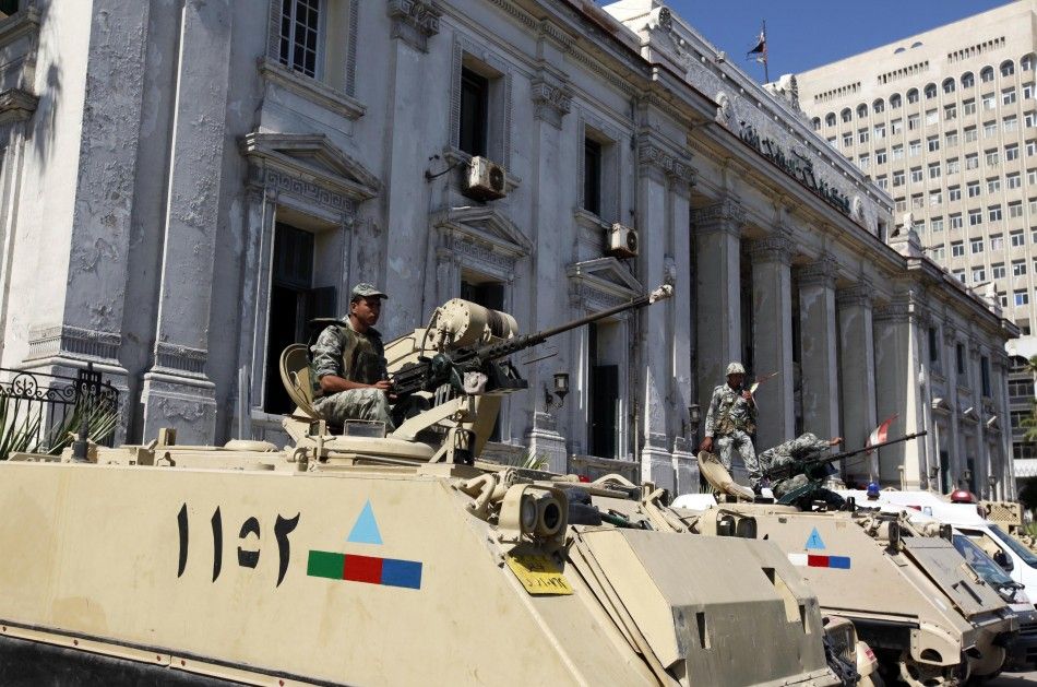 Soldiers atop armoured vehicles stand guard outside court building during trial of two police officers charged with caus...