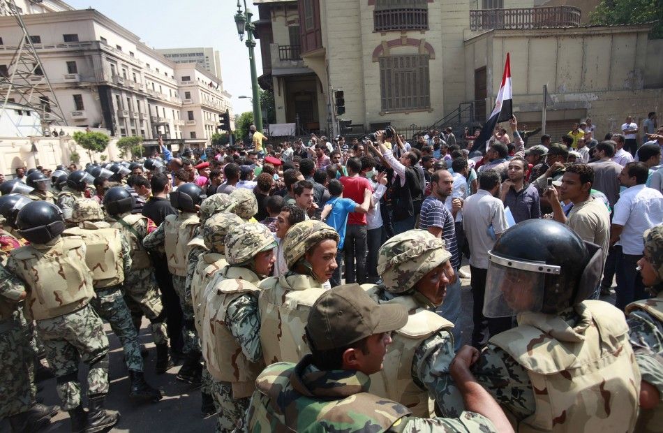 Members of the Army step in to push protesters far from the Interior Ministry after clashes between protesters and riot
