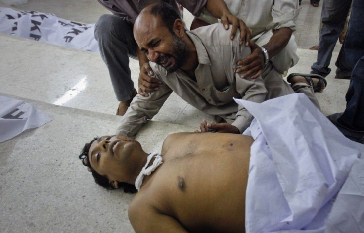A family member of a victim of a target killing cries next to his body at a morgue in Karachi&#039;s Abbasi Shaheed hospital