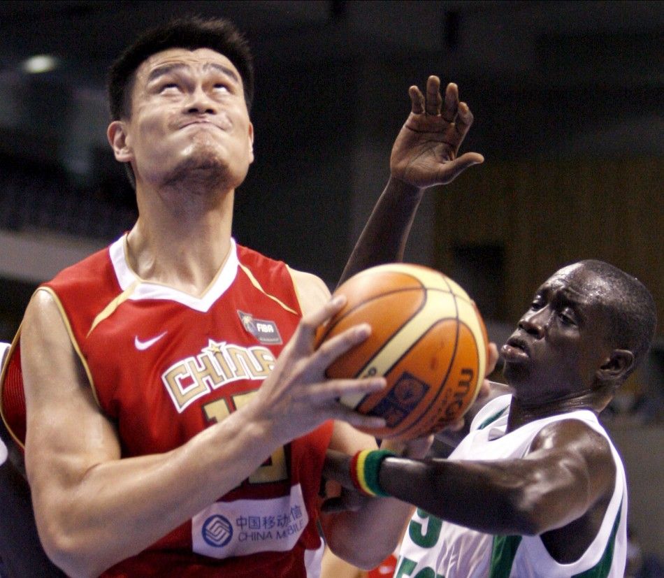Chinas Yao Ming goes up for a shot past Senegals Maleye NDoye during the first round of the world basketball champion