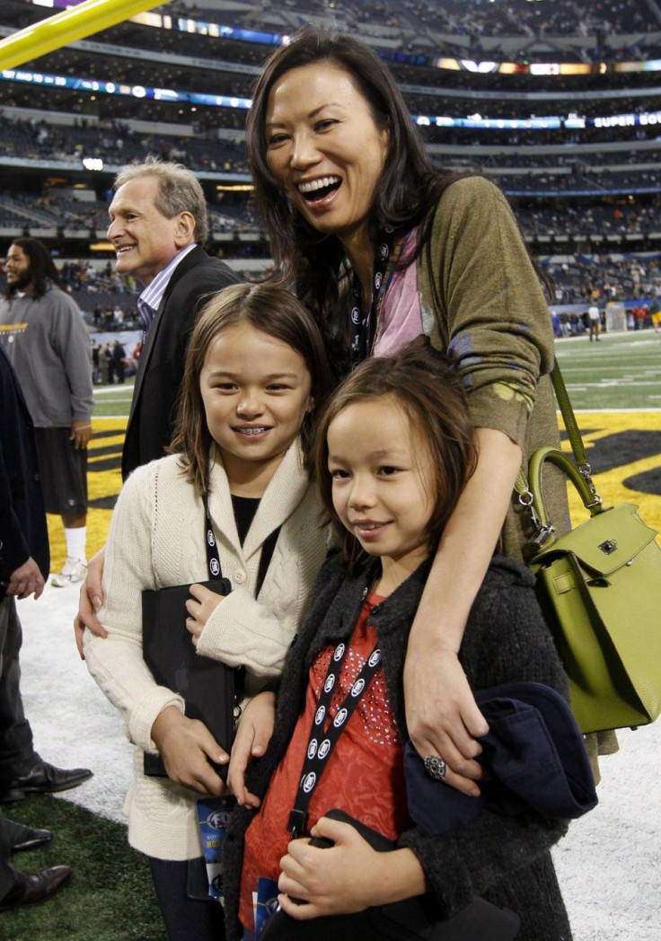 Wendi Deng, wife of media magnate Rupert Murdoch, stands on the field with daughters Chloe Murdoch (R) and Grace Murdoch