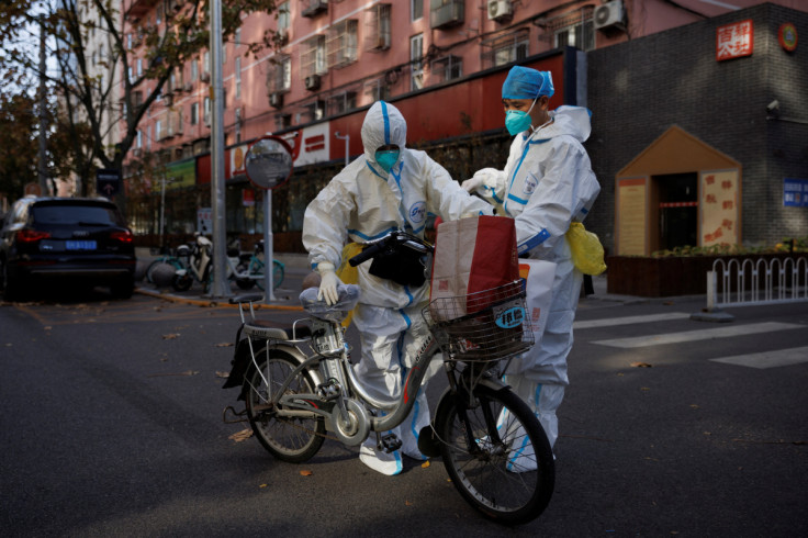 Pandemic prevention workers in protective suits stand on a street as outbreaks of coronavirus disease (COVID-19) continue in Beijing
