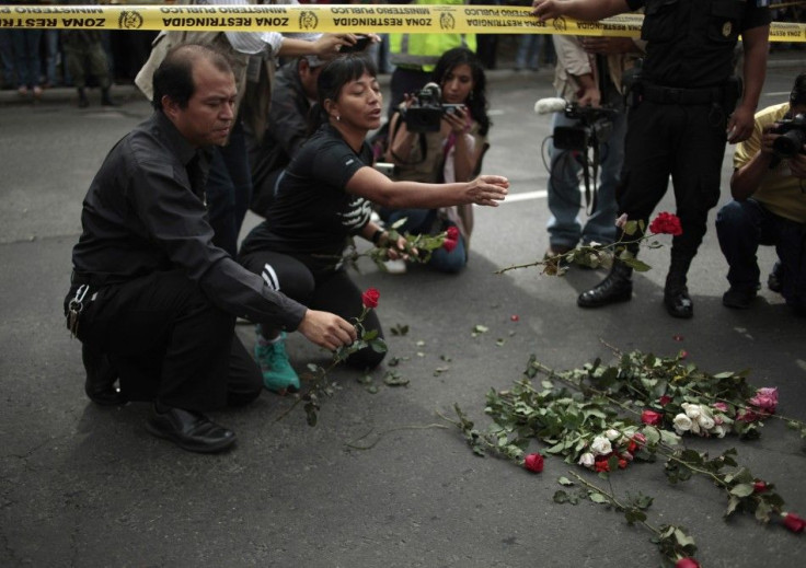 People place flowers in honor of Facundo Cabral at the crime scene where the Argentine singer was shot dead in Guatemala