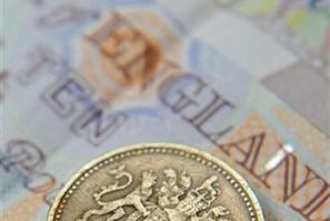 A one pound coin and sterling notes are seen in central London