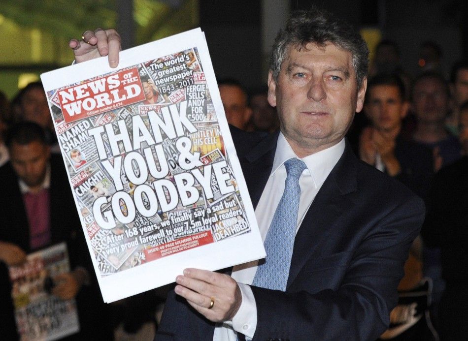 Colin Myler, editor of the News of The World, holds up a copy of the last edition of the newspaper outside the newspapers office in Wapping