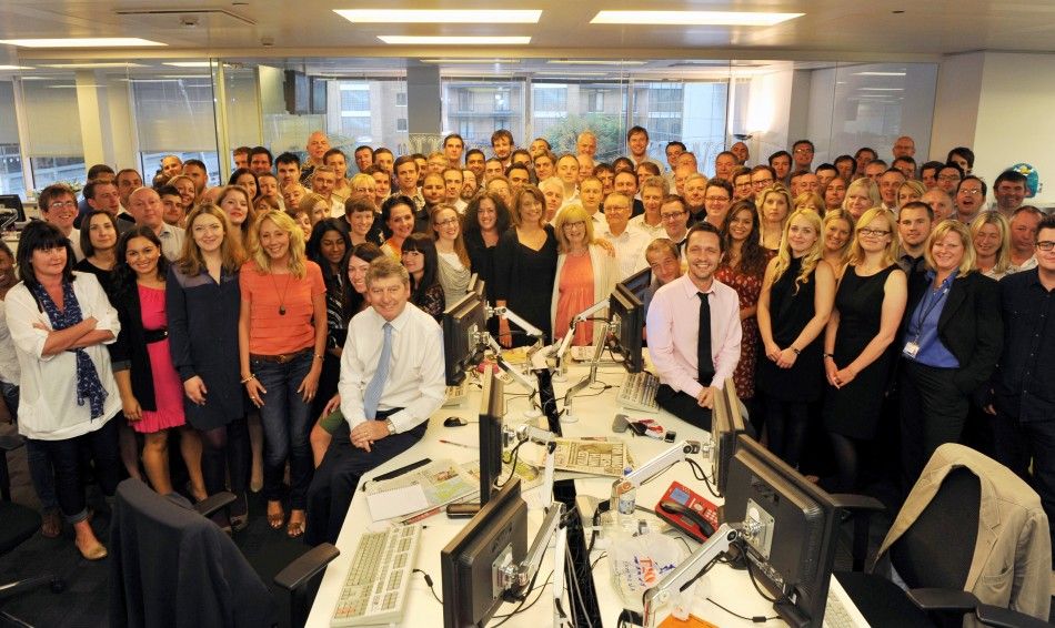 The News Of The World editor Colin Myler poses for a photograph with the staff of the newspaper in their newsroom in London