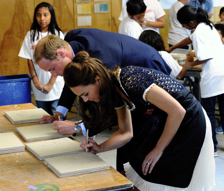 Britains Prince William and his wife Catherine, Duchess of Cambridge, autograph their handprints after attending a ceramics class at the Inner-City Arts campus in Los Angeles, California