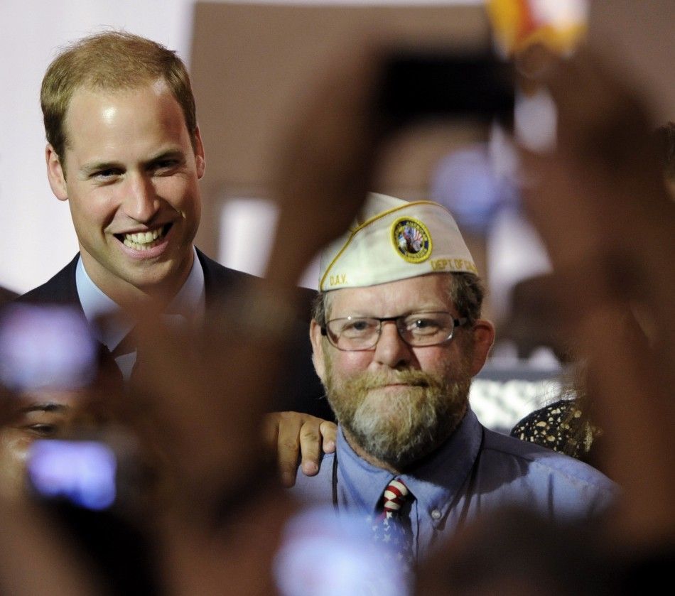 Britains Prince William L poses for a photo with a U.S. military veteran as he attends the Mission Serve Hiring Our Heroes event with his wife Catherine, Duchess of Cambridge not pictured in Culver City, California July 10, 2011