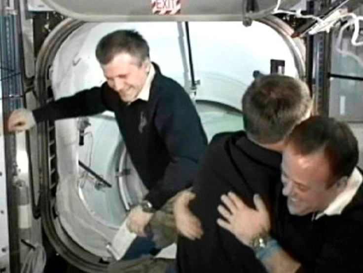 Space shuttle Atlantis Commander Chris Ferguson and station flight engineer Ron Garan hug after docking of the two spacecraft