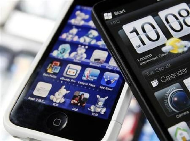 A HTC smartphone and an Apple iPhone are displayed for the photographer at a mobile phone shop in Taiwan