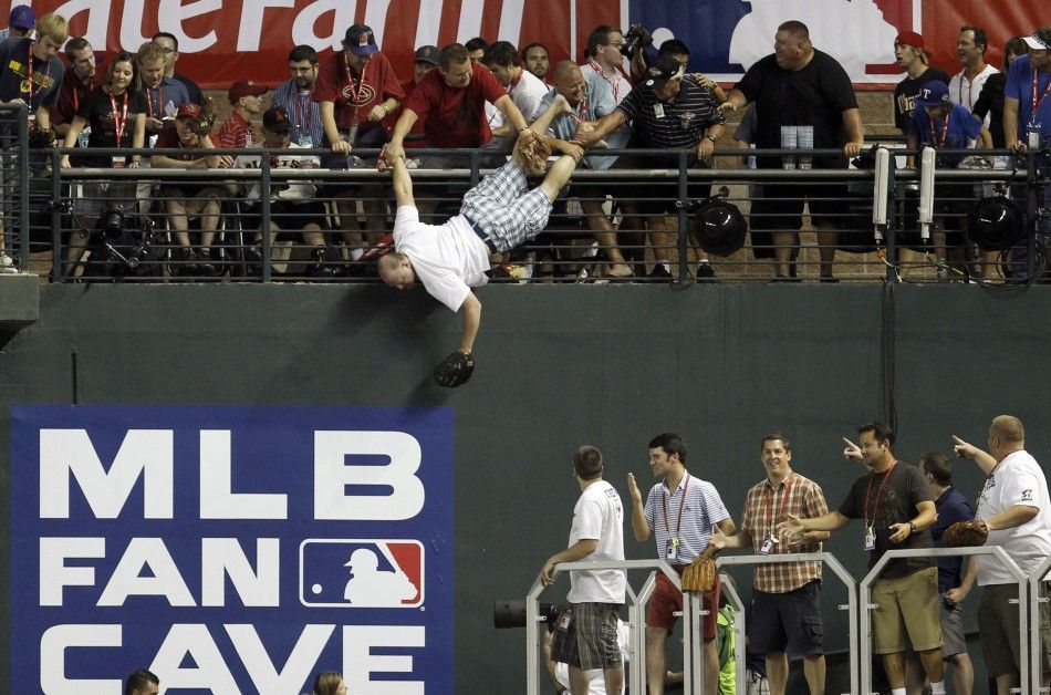 A man is caught after he almost fell headfirst to a pool deck about 20 feet below while trying to catch home run ball during Major League Baseball039s Home Run Derby at the All-Star Game in Phoenix