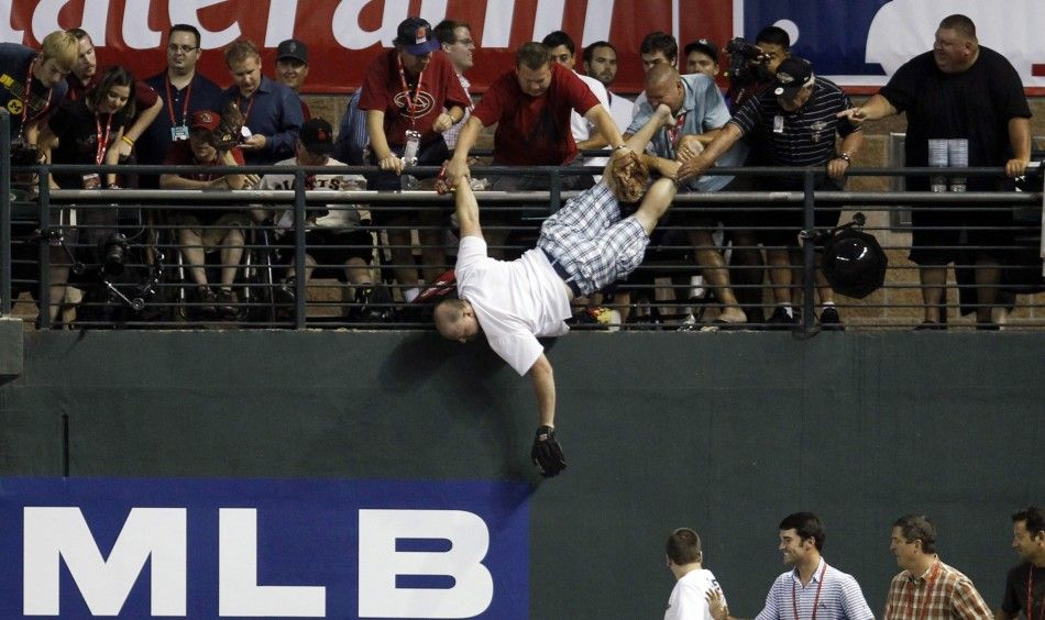 A man is caught after he almost fell headfirst to a pool deck about 20 feet below while trying to catch home run ball during Major League Baseball039s Home Run Derby at the All-Star Game in Phoenix