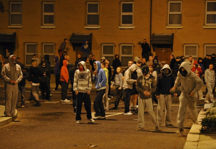 Young hooded demonstrators prepare to attack a police vehicle during a stand-off between loyalist and nationalist demonstrators in east Belfast