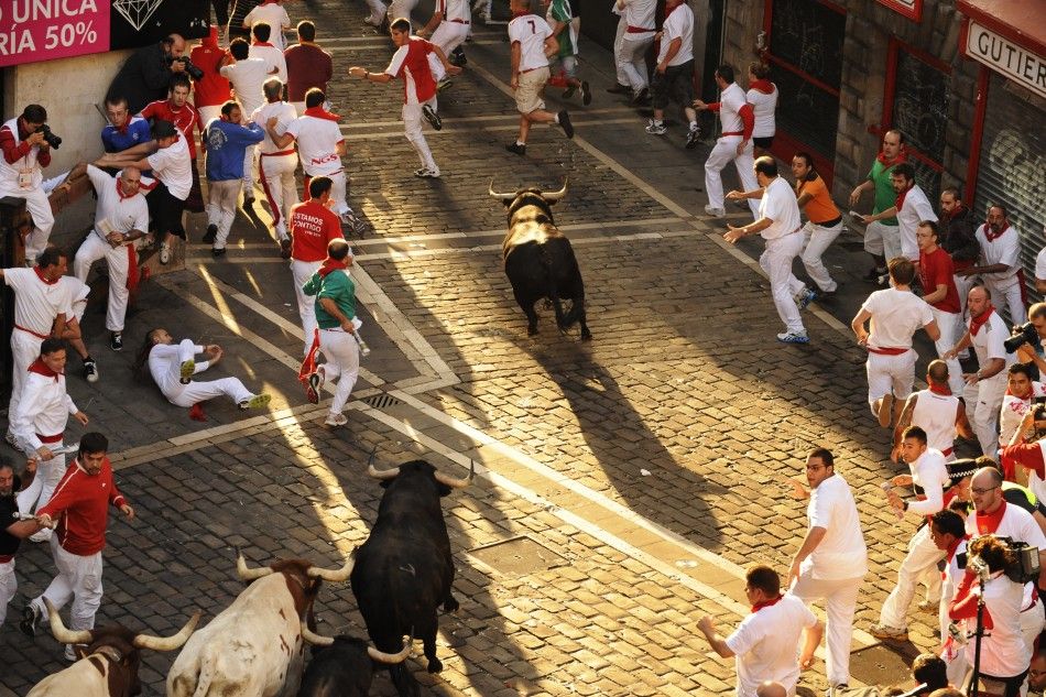 Victoriano del Rio fighting bulls cross the town hall square during the sixth running of the bulls at the San Fermin festival in Pamplona.
