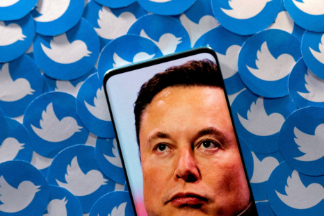 Illustration shows Elon Musk image on smartphone and printed Twitter logos