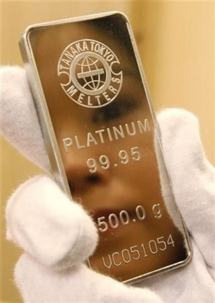 An employee of Tanaka Kikinzoku Jewelry K.K. holds a platinum bar