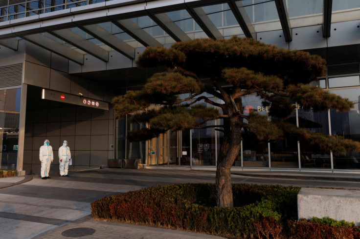 Epidemic prevention workers in protective suits guard the entrance to an office building in the Central Business District (CBD) as outbreaks of the coronavirus disease (COVID-19) continue in Beijing