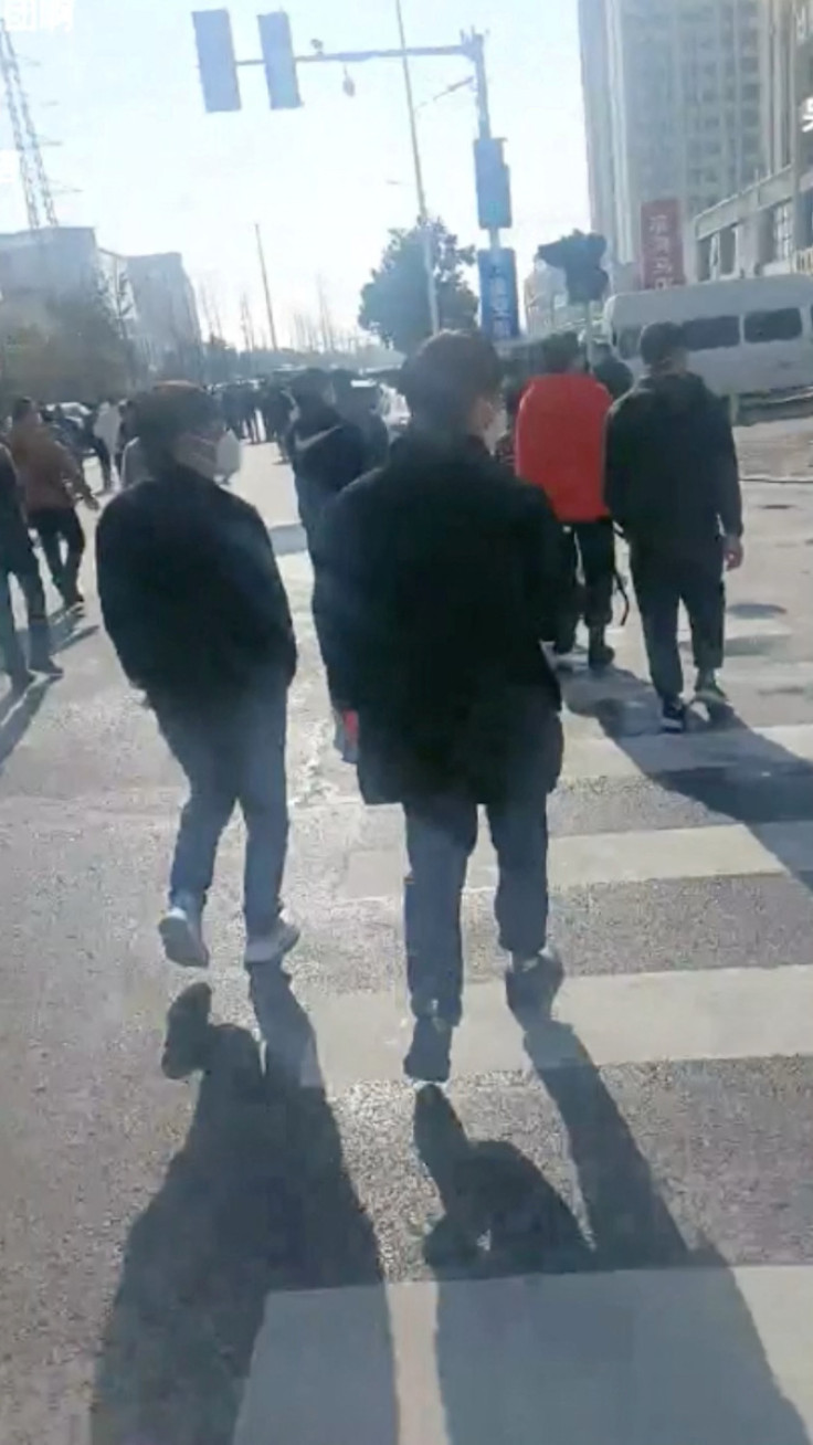 Group of people seem to walk towards the Foxconn factory following a protest at their plant in Zhengzhouu